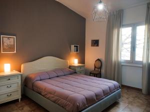 a bedroom with a bed and two night stands and a window at S'Iscala apartment in Lanusei