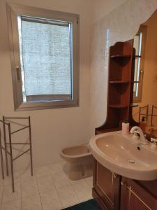 bagno con lavandino, servizi igienici e finestra di S'Iscala apartment a Lanusei