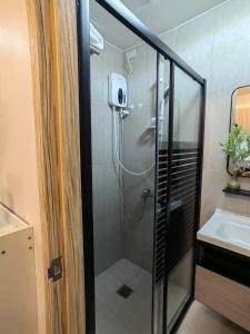 y baño con ducha y lavamanos. en Triann Condo Staycation Davao in Inspiria Condominium Building, en Davao City