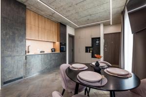 a room with a table and chairs and a kitchen at Pajūrio Oazė MG13 in Klaipėda