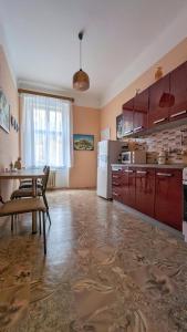 a kitchen with red cabinets and a table in it at Kamil Apartments, Delux, 65 m2 in Karlovy Vary