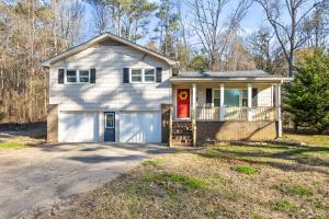 a white house with a red door at The Happy Place: 3BR Home on Quiet Street in Douglasville