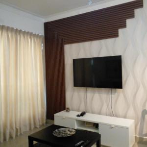 a living room with a flat screen tv on a wall at Cozy apartment in exclusive area Bella Vista in Santo Domingo