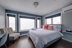 um quarto com paredes azuis e uma cama e uma cadeira em Coastal Lookout Suites em Corner Brook