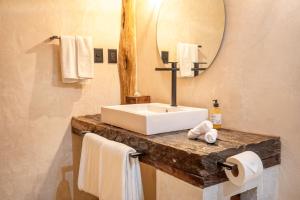 y baño con lavabo, espejo y toallas. en Casa Ganesh Tulum, en Tulum