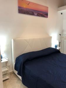 a bedroom with a large bed with a blue blanket at FRONTE MARE in Palermo