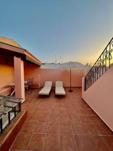 a balcony with benches and a view of the ocean at Riad Dar Hanae in Tétouan