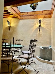 a patio with a table and chairs and a fountain at Riad Dar Hanae in Tetouan