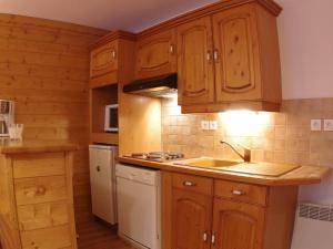 a kitchen with wooden cabinets and a sink and a refrigerator at Appartement Valmorel, 3 pièces, 6 personnes - FR-1-291-765 in Valmorel