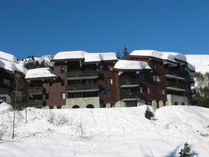 un gran edificio de apartamentos con nieve en el techo en Appartement Valmorel, 3 pièces, 6 personnes - FR-1-291-765, en Valmorel