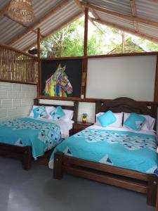2 Betten in einem Zimmer mit einem Pferdekopf an der Wand in der Unterkunft Finca Ecoturistica LOS JAGUEYES in Baraya