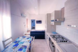 uma pequena cozinha com fogão e bancada em ### Appartamenti sulla SPIAGGIA al POETTO ### em Cagliari