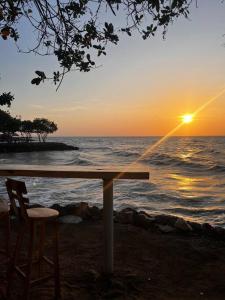 una mesa y sillas en la playa con la puesta de sol en Habitación confortable y terraza Hamacas Coveñas, en Coveñas