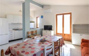 cocina y comedor con mesa y sillas en Pet Friendly Apartment In San Leonardo Di Cutro With Kitchen, en Le Castella