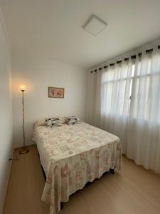 1 dormitorio con 1 cama y una ventana con cortinas en Apartamento Acolhedor e Bem Localizado, en Vila Velha