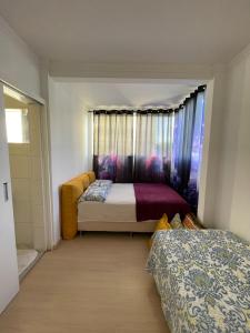 1 dormitorio con 2 camas y ventana en Apartamento Acolhedor e Bem Localizado en Vila Velha