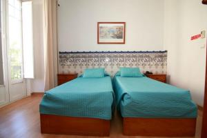 two beds in a room with blue walls at Residencial Joao XXI in Lisbon