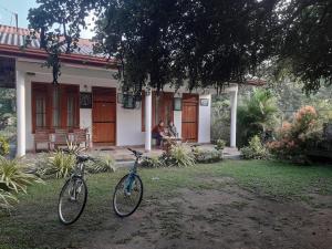 dos bicicletas estacionadas frente a una casa en River Nature Park, en Polonnaruwa