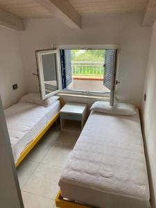 ein kleines Zimmer mit 2 Betten und einem Fenster in der Unterkunft casa montauro in Stalettì