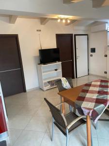ein Wohnzimmer mit einem Tisch, Stühlen und einem TV in der Unterkunft casa montauro in Stalettì