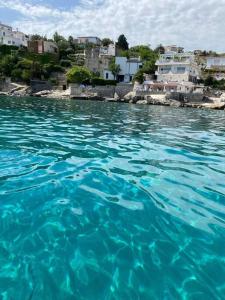 ein großer blauer Wasserkörper mit Gebäuden im Hintergrund in der Unterkunft casa montauro in Stalettì