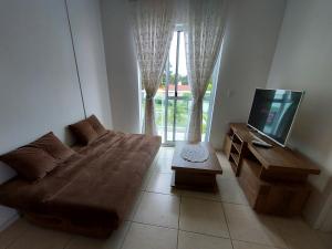 a living room with a couch and a flat screen tv at Praia da Cachoeira in Florianópolis