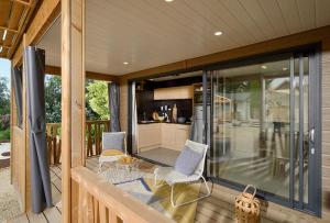 a screened in porch with two chairs and a kitchen at Camping Beau Rivage in Navarrenx