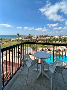 a balcony with a table and chairs and the ocean at Anmaria Beach Hotel & Spa in Ayia Napa