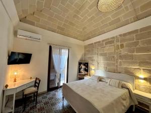 法维尼亚纳NINNI SUITE的一间带床和石墙的卧室