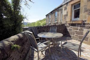 una mesa y sillas en un patio en Comrie Old Schoolhouse, en Comrie