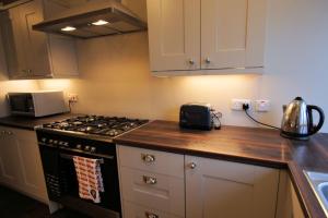 a kitchen with a stove and a microwave at Comrie Old Schoolhouse in Comrie