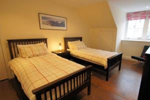 a bedroom with two beds and a window at Comrie Old Schoolhouse in Comrie