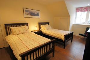 1 dormitorio con 2 camas y ventana en Comrie Old Schoolhouse, en Comrie