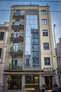 un edificio alto con una gran ventana de cristal en Alva Athens Hotel, en Atenas