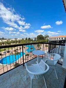 a balcony with a table and chairs and a pool at Anmaria Beach Hotel & Spa in Ayia Napa