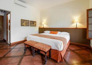a bedroom with a large bed and two chairs at Casa Hacienda San Jose in Chincha Alta
