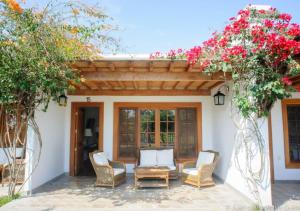 eine Terrasse mit Stühlen und Blumen vor einem Haus in der Unterkunft Casa Hacienda San Jose in Chincha Alta