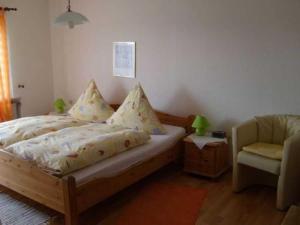 1 dormitorio con 1 cama y 1 silla en Pension Am Limespfad, en Hesseneck