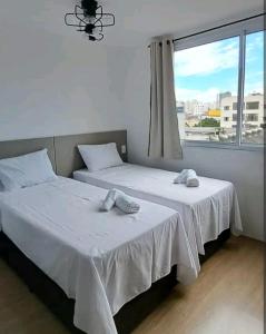 2 camas en una habitación con ventana en Novo e Fantástico Studio no Brás-Piscina, en São Paulo