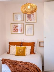 1 dormitorio con 1 cama con lámpara de araña de oro en Appartement cocoon dans maison du XVIIème siècle, en Fougères