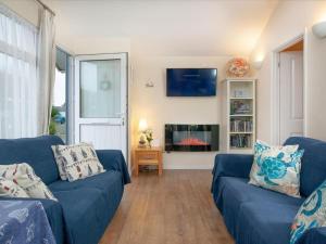 sala de estar con 2 sofás azules y chimenea en Sunnydaze en Dartmouth