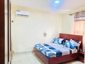 een slaapkamer met een bed met blauwe en witte kussens bij APEX ANNEX Guest Facility in Buea