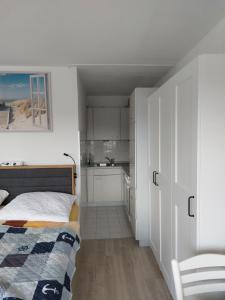 ein kleines Schlafzimmer mit einem Bett und einer Küche in der Unterkunft SPO - gemütliches Apartment - TOP LAGE in Sankt Peter-Ording