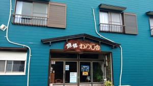 ein blaues Gebäude mit einem Hundeschild drauf. in der Unterkunft Ryokan Warajisha - Vacation STAY 62566v in Goto