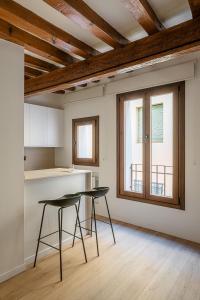 una cocina con 2 sillas y una mesa en una habitación en El Clavel de la Plaza, en Cuenca
