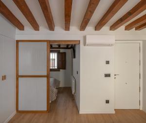 Habitación con una puerta que conduce a un dormitorio en El Clavel de la Plaza, en Cuenca