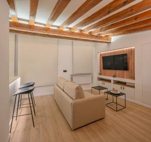 a living room with a couch and a flat screen tv at El Clavel de la Plaza in Cuenca