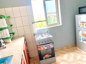 - une cuisine avec une cuisinière et une photo dans l'établissement APEX ANNEX Guest Facility, à Buea