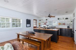 a kitchen with a wooden table and a ceiling fan at Longboard House in Tybee Island