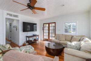 a living room with a couch and a ceiling fan at Longboard House in Tybee Island